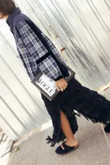 Camisa de corte amplio y elegante, confeccionada en una combinación de telas lisas y a cuadros en tonos azul marino, gris y blanco. Presenta cuello camisero, botonadura frontal y detalles de terciopelo en las mangas y hombros.