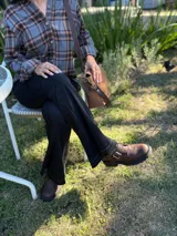 Botas cortas de cuero color marrón con suela track negra. Presentan dos correas ajustables con hebillas metálicas plateadas en el empeine y cierre lateral interno.