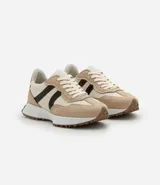 Championes estilo jogging con diseño de paneles en tonos gris, blanco y negro. Presentan cierre por cordones, suela de goma con relieve que se extiende hacia el talón y acabado en poliuretano.