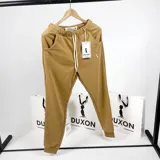 Pantalón de jogging color mostaza de algodón sin felpa, con cintura elástica ajustable con cordón, bolsillos laterales y puños elásticos en los tobillos.