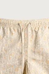 Short de baño de tejido técnico en color beige con estampado paisley en tonos claros y naranjas. Cuenta con cintura elástica con cordón ajustable, bolsillos laterales y forro interior.