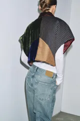 Chaqueta acolchada de diseño patchwork confeccionada en una combinación de tejidos que incluyen terciopelo, lana y satén a rayas. Presenta un corte holgado tipo kimono con forro interior estampado a contraste.