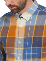 Camisa de manga larga a cuadros en tonos azul, naranja y marrón. Tiene cuello abotonado, bolsillo en el pecho y logo de pingüino bordado.