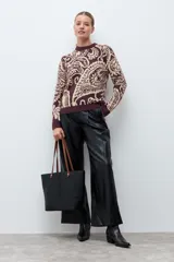Sweater de punto con diseño jacquard de estilo paisley en tonos ciruela y beige, con cuello redondo y mangas largas.