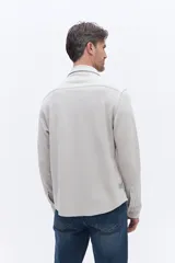 Camisa de manga larga color azul marino, confeccionada en algodón con textura, cuenta con un bolsillo frontal y cierre frontal con botones.