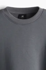 Buzo de tejido de mezcla de algodón de peso medio con interior cepillado suave. Modelo con cuello redondo ribeteado, hombros caídos y remate acanalado ancho en puños y bajo. Corte holgado.