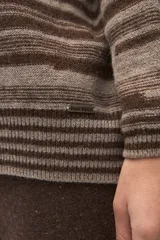 Buzo de tejido de punto con diseño de rayas horizontales en tonos beige y blanco, cuello redondo, hombros caídos y mangas largas.