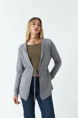 Saco gris de tejido con textura a cuadros y calce relajado. Tiene cintura ajustable con cordón interno y dos bolsillos frontales.