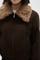 Campera de color marrón con cierre frontal, cuello y puños con detalle de piel sintética en tono beige.
