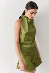 Top halter color marrón brillante, con cuello alto drapeado y espalda media baja.