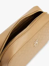 Bandolera Tommy Hilfiger color beige con monograma TH en relieve, cierre de cremallera, correa de cadena dorada extraíble y ajustable, bolsillo interior con cremallera, monedero extraíble con cremallera y logo TH dorado en el frente.