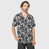 Camisa de manga corta con cuello solapa, confeccionada en viscosa con estampado tropical en tonos verdes, negros y grises.