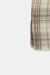 Top de escote recto con vuelta, diseño de hombros descubiertos y manga larga con abertura en el puño. Presenta un estampado de cuadros en tonos neutros.