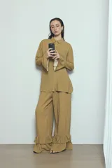 Camisa marrón de viscosa con diseño a rayas sutiles, cuello camisero, cierre frontal de botones y mangas largas con volados acampanados en los puños.