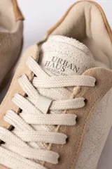 Championes urbanos de diseño retro, confeccionados en una combinación de gamuza y cuero texturizado en tonos beige y arena. Presentan cordones al tono y una suela dentada de goma en color caramelo.
