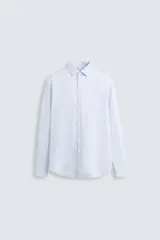 Camisa de vestir blanca de algodón, corte slim fit, con cuello italiano y manga larga terminada en puño con botón.