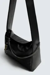 Bolso tipo bandolera de cuero sintético negro, con asa de hombro y detalle de cadena metálica plateada en el frente. Incluye un charm colgante con forma de llave.