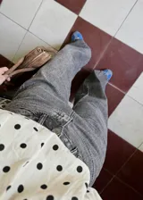 Pantalón jean azul oscuro, de corte wide leg y tiro medio. Presenta detalles de costuras diagonales en la parte superior.