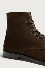 Bota de caña baja tipo derby confeccionada en piel con acabado serraje en color marrón, con cordones oscuros y suela con ligero tacón.