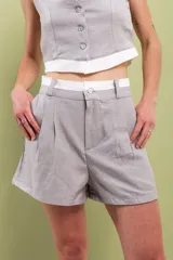 Short gris de lino y algodón, tiro alto, con doble pinza delantera, doble pretina y botón de nácar.