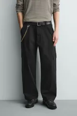 Pantalón cargo de corte relajado confeccionado en tejido de algodón con elasticidad. Presenta bolsillos laterales tipo cargo con solapa en las perneras, bolsillos frontales y bolsillos traseros de doble vivo. Cierre frontal con cremallera y botón.
