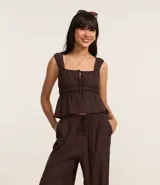 Pantalón recto de tiro medio, confeccionado en viscosa texturizada color bordó. Presenta cintura elástica con lazo ajustable y diseño de pierna recta y fluida.
