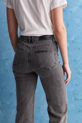 Jean de tiro alto con corte recto, confeccionado en denim con spandex. Presenta un lavado gris oscuro con efecto desgastado, cierre frontal con botón y bolsillos laterales y traseros.