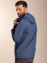 Campera de nylon con capucha, cierre frontal y forro de red. Presenta un diseño minimalista en color beige con detalles en negro.