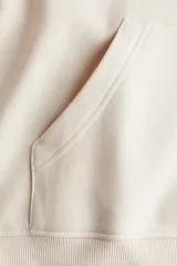 Buzo con capucha de doble capa, hombros caídos y bolsillo canguro frontal. Presenta puños y bajo acanalados.