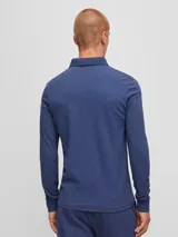 Remera polo de manga larga azul de algodón, corte slim fit, con cuello clásico y tapeta de dos botones. Incluye un pequeño bolsillo cuadrado en el pecho con el logo de la marca. 