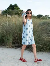 Vestido corto celeste con lunares grandes color azul, sin mangas y corte recto.