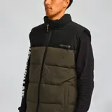 Chaleco acolchado Caterpillar con diseño bicolor en negro y verde oliva. Presenta cierre frontal completo, cuello alto, bolsillos laterales con cierre y logo de la marca estampado en el pecho.
