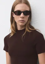 Vestido corto de tejido de punto fino en color marrón chocolate, con cuello perkins y mangas cortas. Presenta un diseño evasé que se ajusta suavemente al cuerpo.