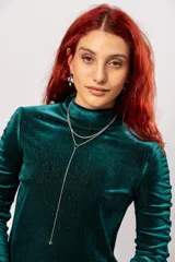 Polera de manga larga color verde petróleo con detalle de drapeado en las mangas. Confeccionada en terciopelo velvet con lurex.