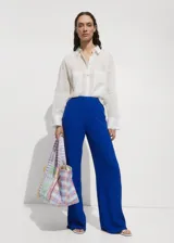 Pantalón de corte recto y tiro alto, confeccionado en tejido fluido con textura. Presenta cintura elástica para mayor comodidad.