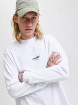 Remera de manga larga con cuello redondo y calce relajado, confeccionada en algodón orgánico. Presenta un diseño minimalista con un pequeño logo estampado en el centro del pecho.