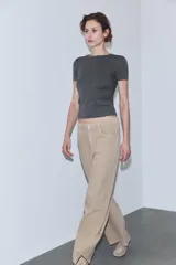 Jeans de tiro alto, color beige claro, con pierna ancha y cinco bolsillos.