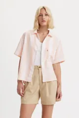 Camisa de manga corta Levi's con diseño de rayas verticales en tonos blanco y durazno. Presenta cuello clásico, cierre frontal con botones y un bolsillo en el pecho con la etiqueta roja característica de la marca.