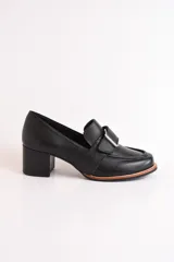 Mocasín negro de cuero con hebilla metálica plateada y taco cuadrado.