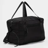 Bolso deportivo de diseño acolchado en color menta, con compartimento lateral independiente para calzado, cierre frontal y correas de mano con logo estampado. Incluye correa ajustable para el hombro.