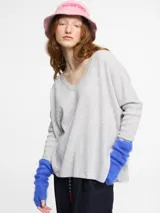 Sweater de punto fino color gris claro, con escote en V pronunciado y manga larga. Presenta un calce relajado y holgado.