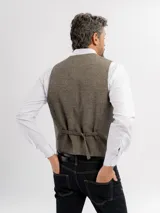Chaleco de paño con escote en V, cierre frontal con botones y bolsillos tipo ojal. Presenta un diseño clásico de corte regular.