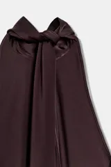 Top de cuello halter confeccionado en tejido satinado, con diseño asimétrico y caída fluida. Presenta lazada ajustable en la espalda.