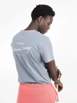 Camiseta celeste de manga corta con cuello redondo y estampado en la espalda con el logo de la marca y la frase "Naturally Vintage".