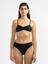 Conjunto de bikini negro brillante, compuesto por un corpiño con breteles finos y una bombacha de corte clásico.