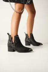 Botines texanos de cuero color marrón con diseño de piel de serpiente, corte en V en los laterales, apliques de tachas metálicas y hebilla decorativa. Taco de madera.