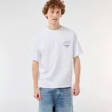 Remera blanca de manga corta, confeccionada en algodón liso, con diseño de estampado pequeño en el pecho y calce holgado.