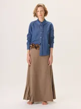 Camisa de algodón con cuello clásico y detalle de volados en la cartera delantera. Presenta mangas largas con puños abotonados y un diseño de corte recto.