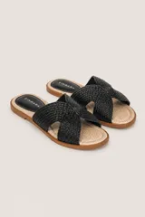 Sandalias planas marca Zingara con tiras cruzadas negras de textura trenzada y plantilla de rafia con talón en eco-cuero negro.