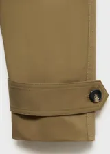 Abrigo tipo trench de diseño recto y oversize, color verde oliva. Presenta cierre de doble botonadura, cuello de solapa ancha, bolsillos laterales y mangas largas con puños abotonados. Incluye forro interior y cinturón desmontable.